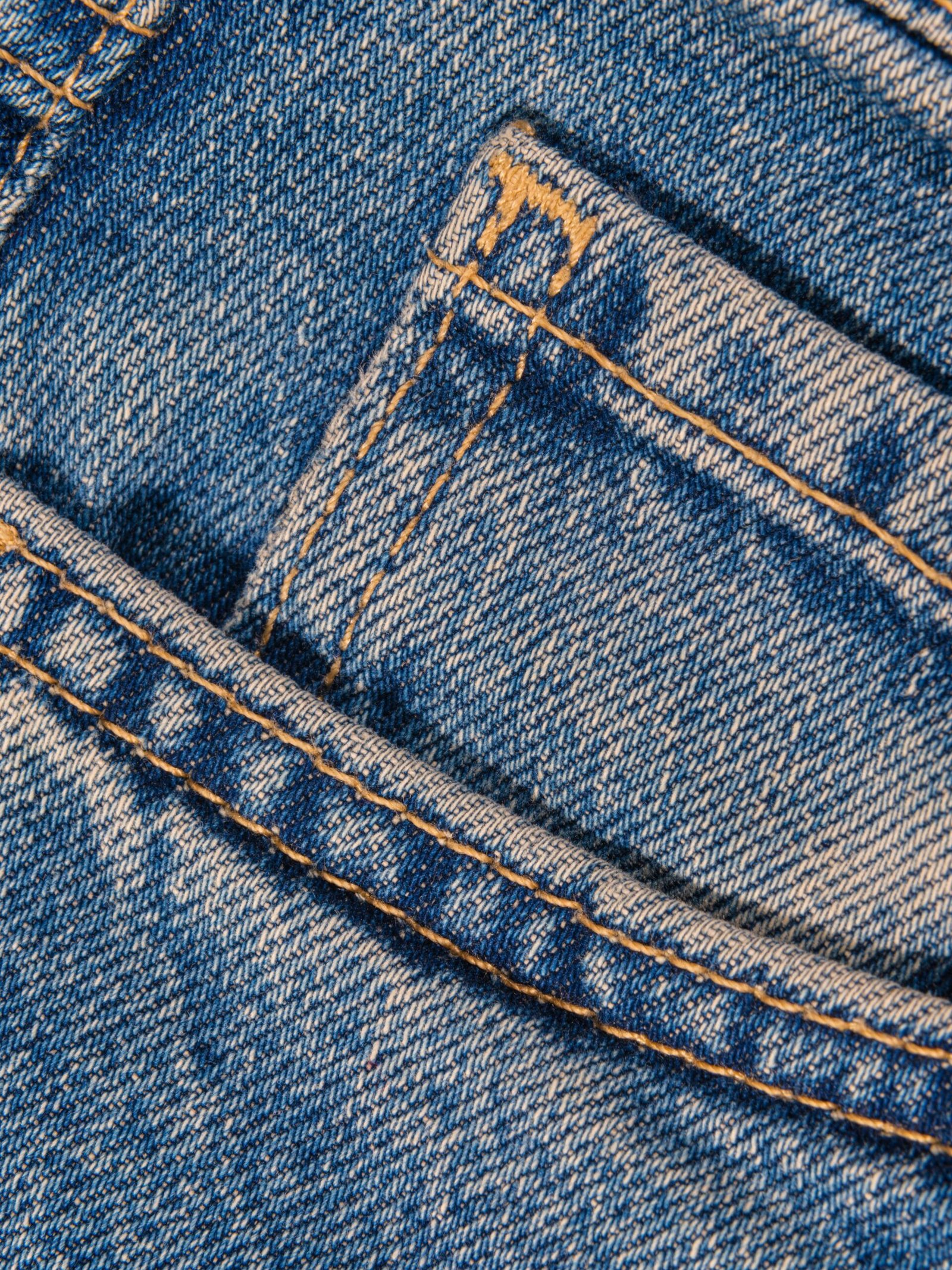 Detailed view of a denim jeans pocket showcasing fabric texture and stitching.