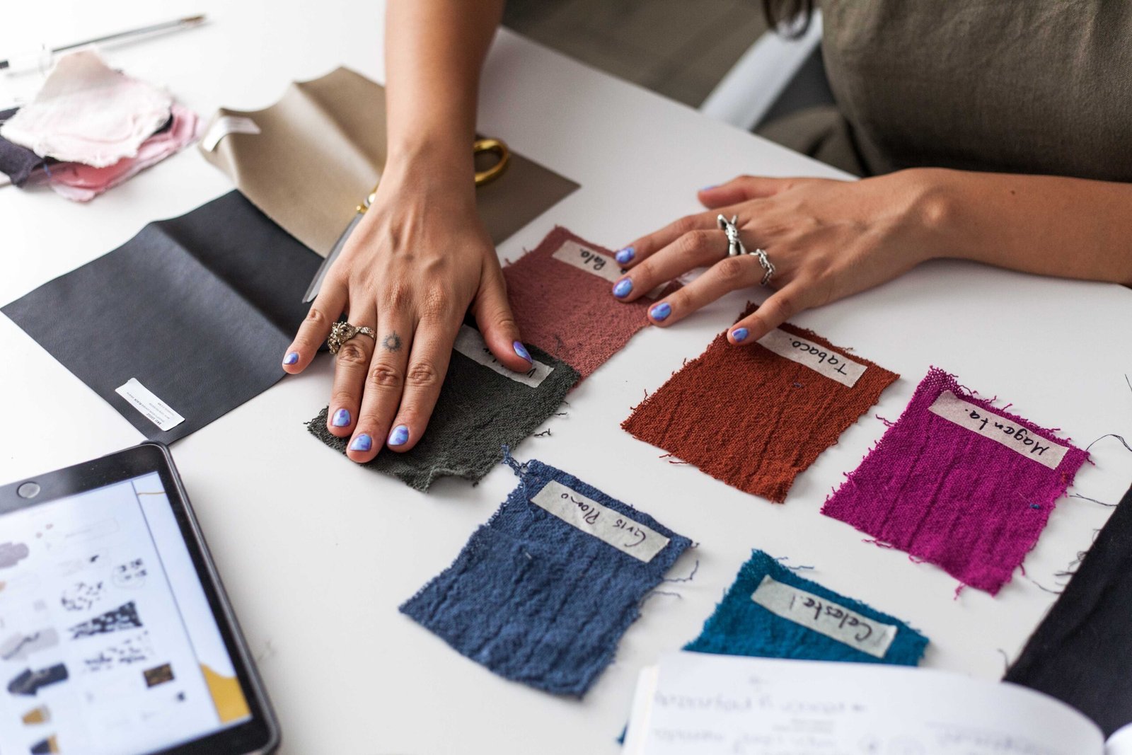 Fashion designer evaluating textile swatches for a new collection in a studio.